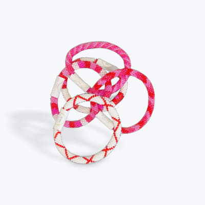 Stack of beaded pink and white bracelets on a white background