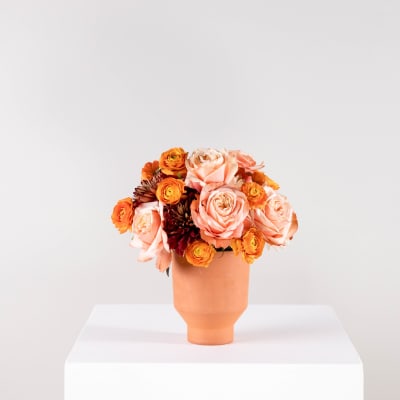 Peach and orange rose bouquet in a terracotta vase