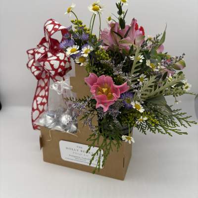 Mixed bouquet in a cardboard gift box with a red heart ribbon