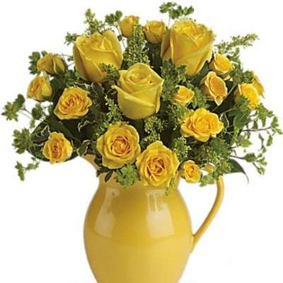 Yellow roses arranged in a yellow pitcher vase