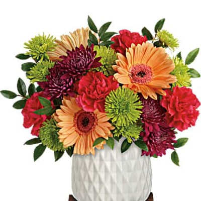 Mixed bouquet of gerbera daisies and chrysanthemums in a white vase