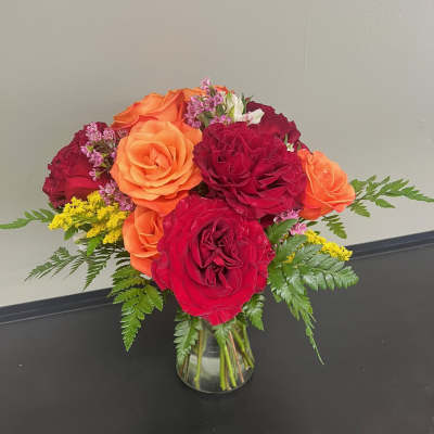Bouquet of red and orange roses in a clear glass vase