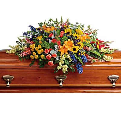 Colorful floral casket spray on a wooden coffin