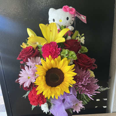 Bouquet of mixed flowers with a Hello Kitty plush in a purple vase