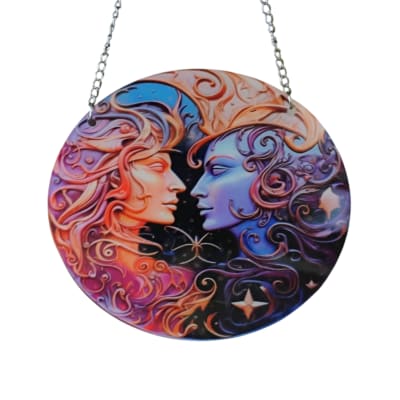 Round hanging plaque with two stylized faces in colorful swirls