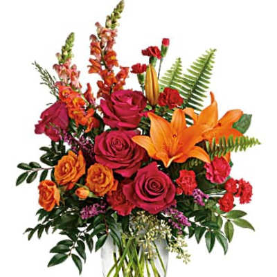 Bouquet of orange lilies and pink roses in a clear glass vase