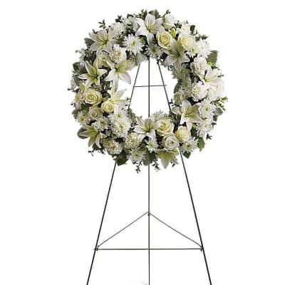 White floral wreath on a black standing easel