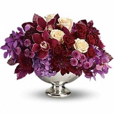 Purple and burgundy floral arrangement in a silver pedestal bowl