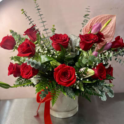 Red roses and pink lilies in a white hat box with a red ribbon