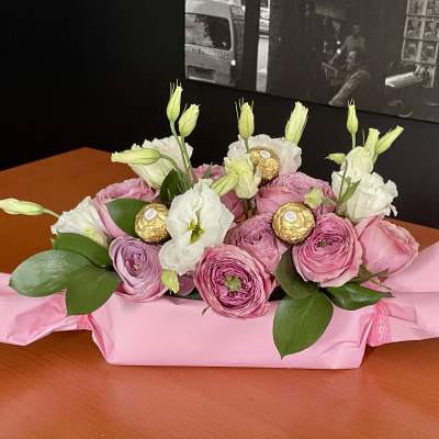 Pink and white flower bouquet with gold-wrapped chocolates on pink paper