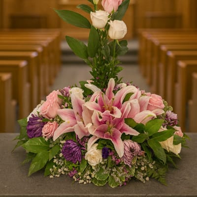 Pink lilies and roses arranged in a church setting