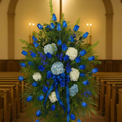 Blue rose funeral spray with white and pale blue flowers