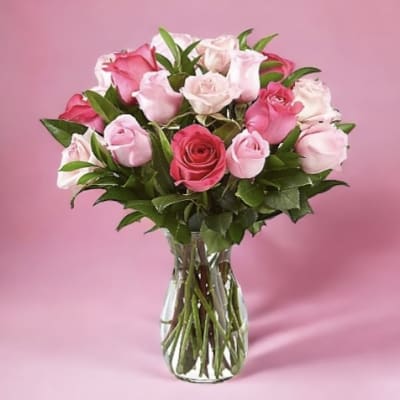Pink and white roses arranged in a clear glass vase