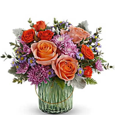 Mixed bouquet of orange and peach roses in a glass vase