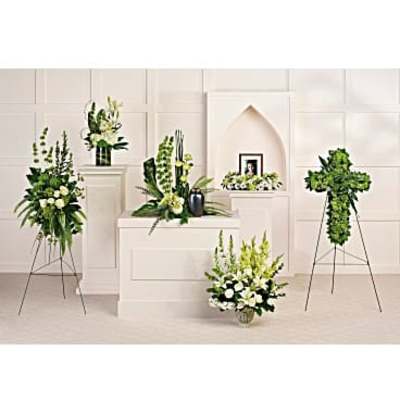 White floral funeral arrangements on pedestals and stands