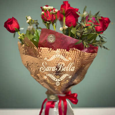 Bouquet of red roses wrapped in brown paper with a red ribbon