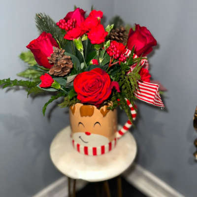 Red roses and carnations in a festive Santa mug with ribbon