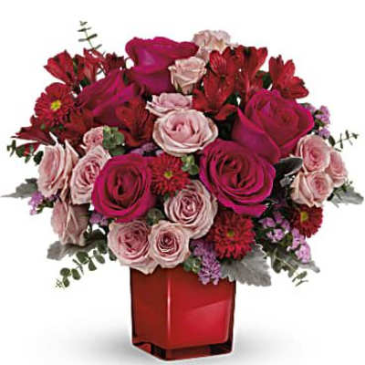 Bouquet of red and pink roses in a red glass vase