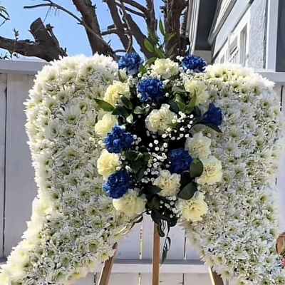 Large white floral heart on an easel with blue and yellow accents
