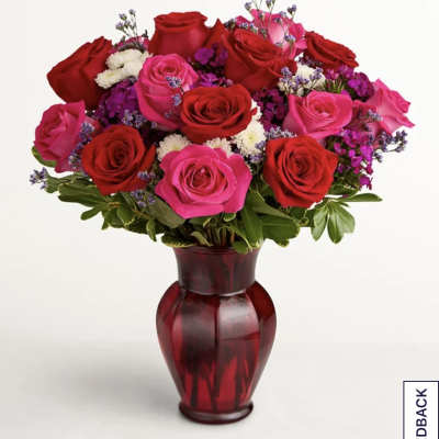 Bouquet of red and pink roses in a red glass vase