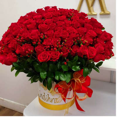 Large bouquet of red roses in a white hatbox with a red ribbon