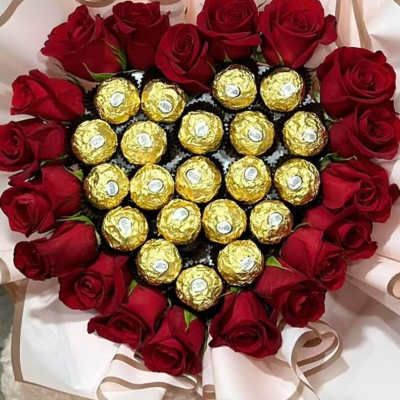 Heart-shaped bouquet of red roses with gold-wrapped chocolates