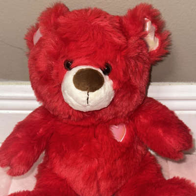 Red plush teddy bear with heart patches