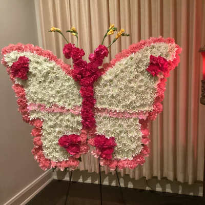 Butterfly-shaped floral display in pink and white on a stand