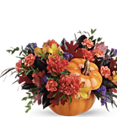 Pumpkin centerpiece with red, yellow, and purple flowers