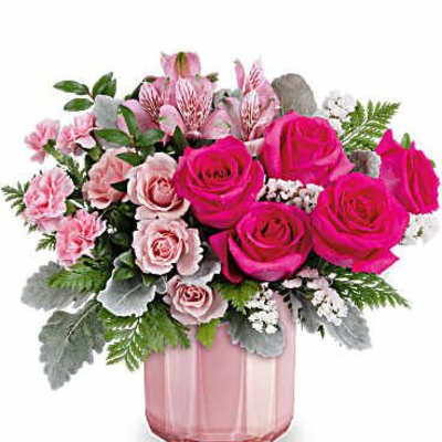 Pink roses and carnations arranged in a pink glass vase