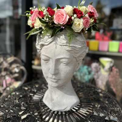 Pink and white rose crown on a stone bust planter