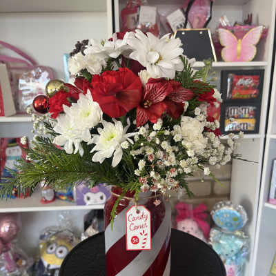 Red and white floral arrangement in a candy cane vase