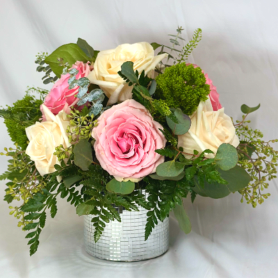 Pink and cream roses in a silver mosaic vase