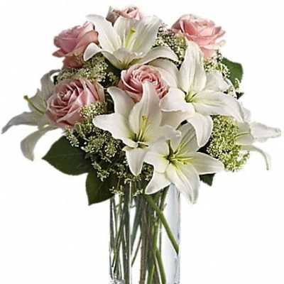 Pink roses and white lilies in a clear glass vase