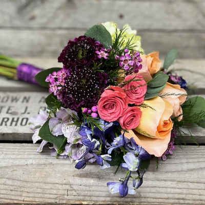 Mixed bouquet with pink and peach roses and purple flowers