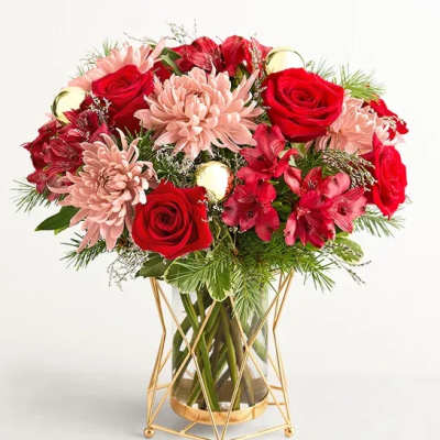 Red roses and pink chrysanthemums in a glass vase with a gold stand