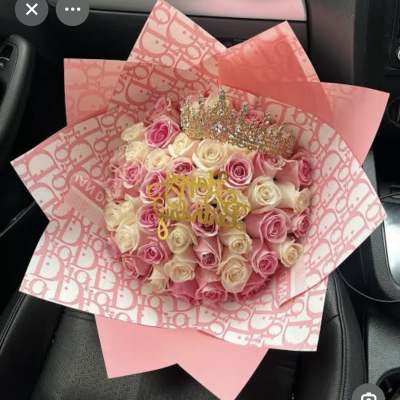 Pink and cream rose bouquet wrapped in patterned pink paper