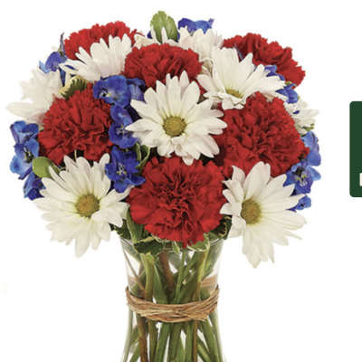 Red carnations and white daisies in a glass vase with blue accents