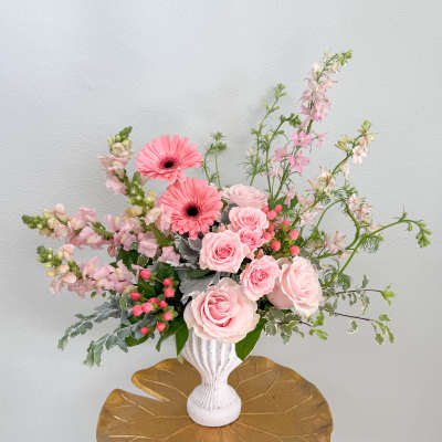 Pink roses and gerbera daisies in a white vase