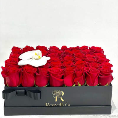 Box of red roses with a white orchid accent