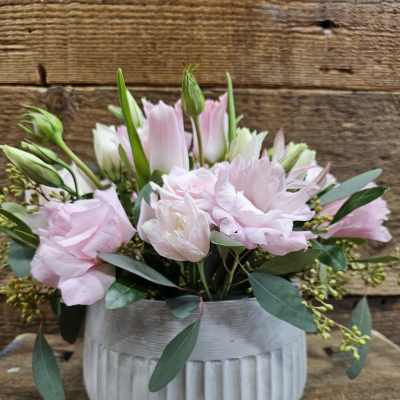 Pink and white flowers arranged in a ribbed white vase