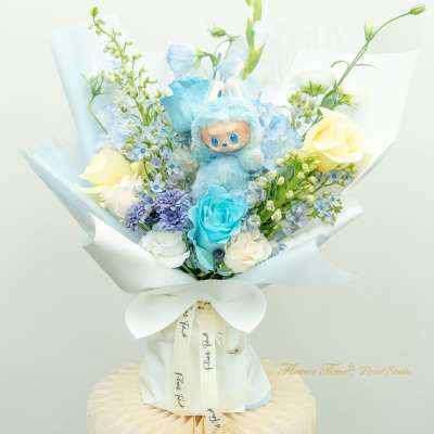 Blue plush toy in a bouquet of pastel flowers with white wrapping