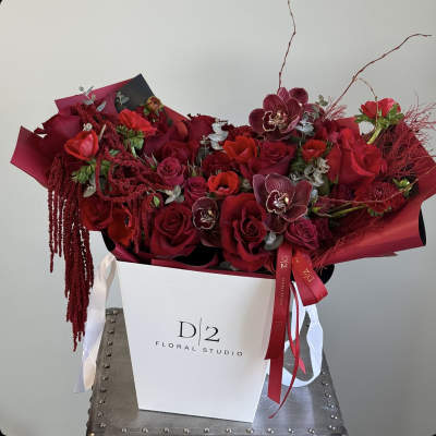 Red rose bouquet with orchids in a white gift box