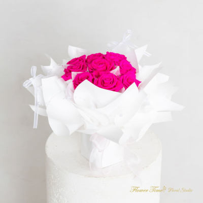 Bouquet of bright pink roses wrapped in white paper