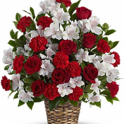 Red roses and white flowers arranged in a woven basket