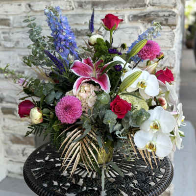 Mixed bouquet with pink roses, white orchids, and a pink lily in a vase