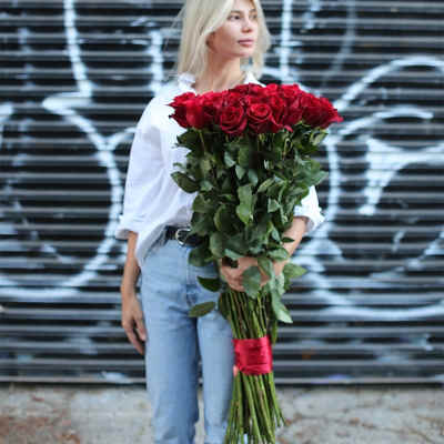 Woman holding a large bouquet of red roses