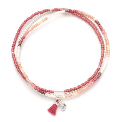Multi-strand pink, peach, and white beaded wrap bracelet with small tassel and charm