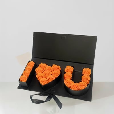 Black gift box with orange roses arranged as I love you