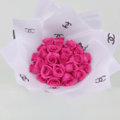 Bouquet of bright pink roses wrapped in white paper